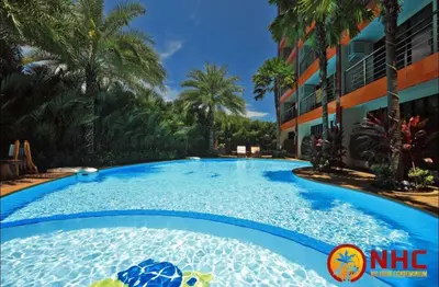 a large swimming pool in front of a building at Nai Harn Condominium in Rawai Beach