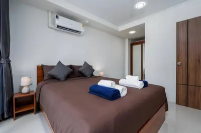 a bedroom with a large bed with two pillows on it at 1 BR apartment 777 Beach Condotel in Mai Khao Beach