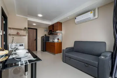 a living room with a couch and a kitchen at 1 BR apartment 777 Beach Condotel in Mai Khao Beach