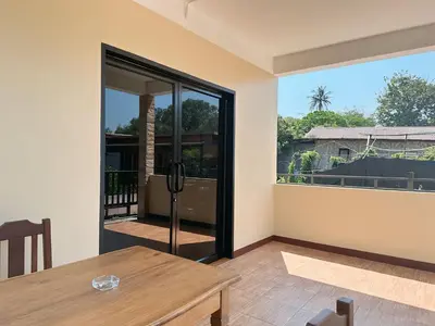 a dining room with a table and a glass door at บ้านสวยกานต์ชนิต in Ko Yao Noi