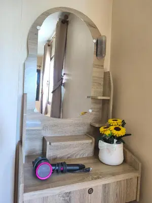 a mirror on a wooden shelf with a camera and flowers at บ้านสวยกานต์ชนิต in Ko Yao Noi
