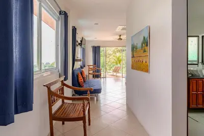a living room with a chair and a couch at Kamala Heights Villa in Kamala Beach