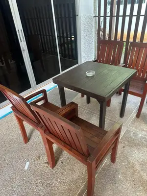 a wooden table and two chairs and a wooden table and bench at Bestin Karon 1 - Apartment GF- 1 min from Karon beach in Karon Beach
