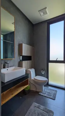 a bathroom with a sink and a toilet and a mirror at Charming Beachside Studio in Rawai Beach