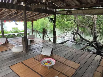 a wooden deck with a table and a bowl on it at Ganchanid House in Ko Yao Noi