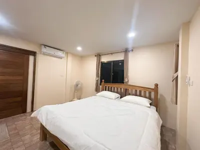 a bedroom with a large white bed and a window at Ganchanid House in Ko Yao Noi