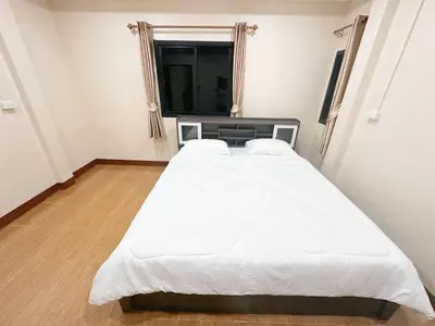 a large white bed in a room with a window at Ganchanid House in Ko Yao Noi