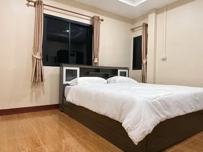 a bedroom with a large bed and a window at Ganchanid House in Ko Yao Noi
