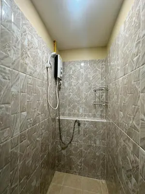 a bathroom with a shower with a phone on the wall at Ganchanid House in Ko Yao Noi