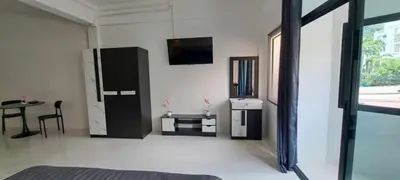 a living room with a black refrigerator and a table at The pink palace in Karon Beach