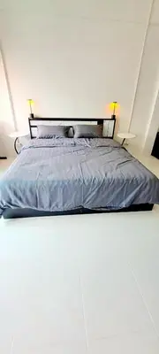a bed in a white room with two lamps on top at The pink palace in Karon Beach