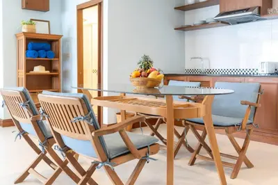 a dining room table with chairs and a bowl of fruit at Waterfront High Tide Suite - Ocean View in Karon Beach