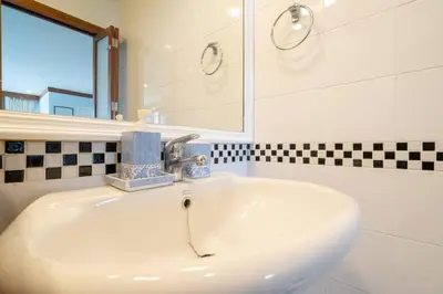 a bathroom with a white sink and a mirror at Waterfront High Tide Suite - Ocean View in Karon Beach