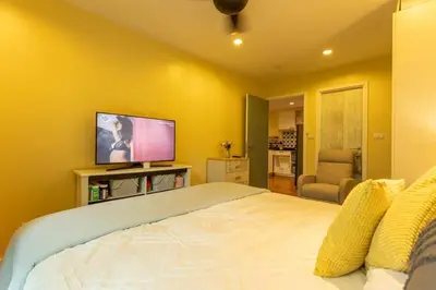 a bedroom with a large bed and a flat screen tv at Neatest Apartment 50m To Main Street And Beach C149 in Rawai Beach