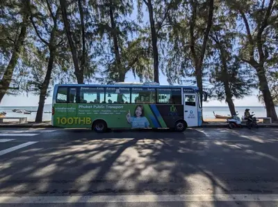 a bus parked in a parking lot next to the ocean at Neatest Apartment 50m To Main Street And Beach C149 in Rawai Beach