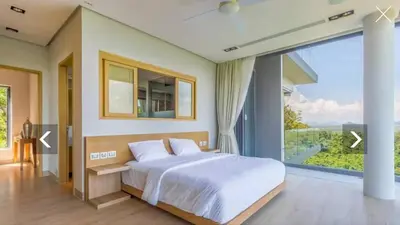 a bedroom with a large bed and a large window at Ocean Heart 5BDR Seaview LUX villa in Ban Bang La