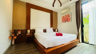 a bedroom with a bed with two red apples on it at Rawaii Vip Villa 2D101 in Phuket Town