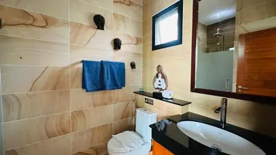 a bathroom with a sink and a toilet and a mirror at Rawaii Vip Villa 2D101 in Phuket Town