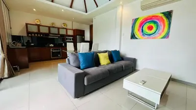 a living room with a couch and a colorful painting at Rawaii Vip Villa 2D101 in Phuket Town
