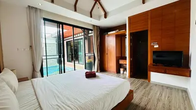 a bedroom with a large bed and a television at Rawaii Vip Villa 2D101 in Phuket Town