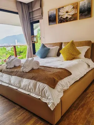 a bedroom with a large bed with a window at modern hill villa \u5c71\u95f4\u89c2\u6d77\u79c1\u4eba\u522b\u5885 in Patong Beach