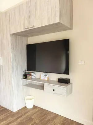 a living room with a tv on a wall at modern hill villa \u5c71\u95f4\u89c2\u6d77\u79c1\u4eba\u522b\u5885 in Patong Beach