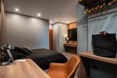 a bedroom with a bed and a table and a television at Three Double U - Kalim Sea View in Patong Beach
