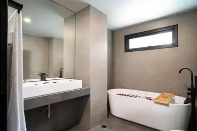 a bathroom with a white tub and a sink and a bath tub at Three Double U - Kalim Sea View in Patong Beach