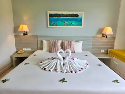 two swans are forming a heart on a bed at ON Hotel Phuket - SHA in Karon Beach