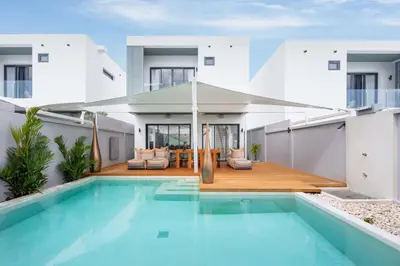 a house with a swimming pool in front of a house at VILLA Satori 4BR by Tropiclook in Rawai Beach