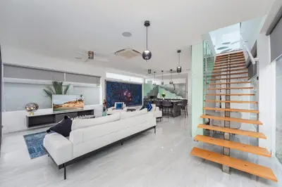 a living room with a white couch and a staircase at VILLA Satori 4BR by Tropiclook in Rawai Beach