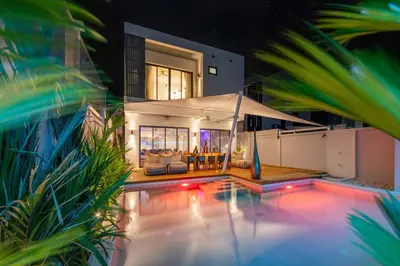 a house with a swimming pool at night at VILLA Satori 4BR by Tropiclook in Rawai Beach