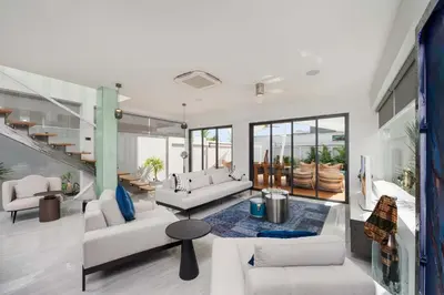 a living room with white furniture and a staircase at VILLA Satori 4BR by Tropiclook in Rawai Beach
