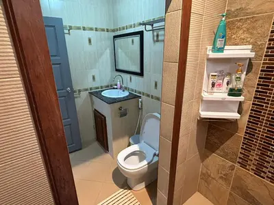 a small bathroom with a toilet and a sink at Cozy Garden Cottage in Ao Nang