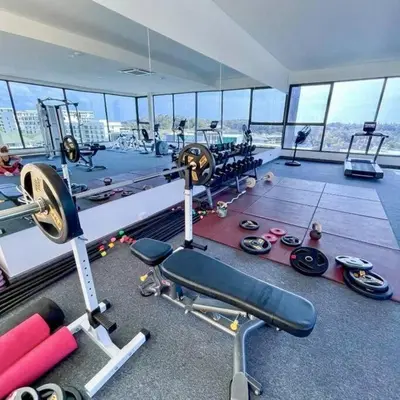 a gym with a lot of equipment in a building at One bedroom apartment Calypso Garden in Phuket Town