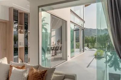 a living room with glass walls and a couch at Luxury Golfside Villa near Patong - Villa Priva in Kathu
