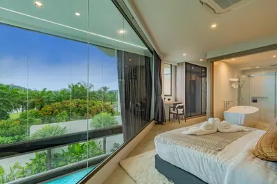 a bedroom with a large window and a bed and a tub at Luxury Golfside Villa near Patong - Villa Priva in Kathu