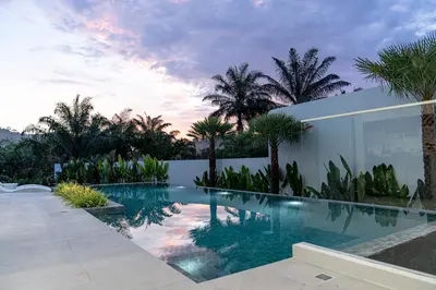 a swimming pool in a house with palm trees at Luxury Golfside Villa near Patong - Villa Priva in Kathu