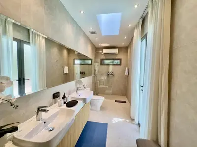 a bathroom with two sinks and a toilet and a mirror at Pool villa at The Residence near BangTao beach in Bang Tao Beach