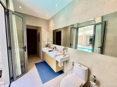 a bathroom with a toilet and a sink and a mirror at Pool villa at The Residence near BangTao beach in Bang Tao Beach