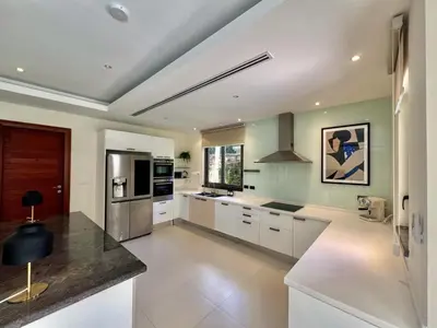 a kitchen with white cabinets and a counter top at Pool villa at The Residence near BangTao beach in Bang Tao Beach