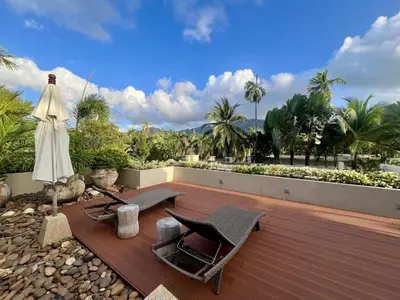 a deck with two chairs and an umbrella and a table at Pool villa at The Residence near BangTao beach in Bang Tao Beach