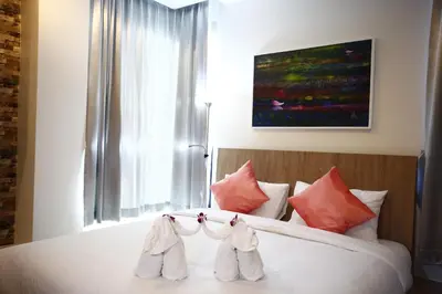 a bedroom with a bed with two baby shoes on it at Buasri By Ohm in Patong Beach