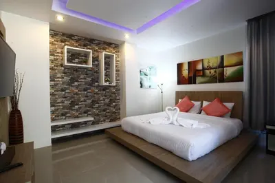 a bedroom with a large white bed with red pillows at Buasri By Ohm in Patong Beach
