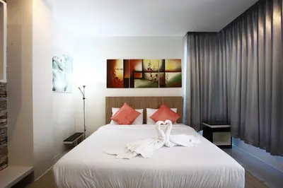 a bedroom with a white bed with red pillows at Buasri By Ohm in Patong Beach