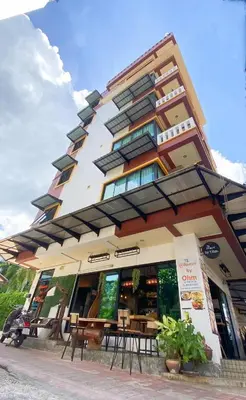 a building with tables and chairs in front of it at Buasri By Ohm in Patong Beach