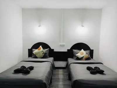 a room with two beds with black pillows at White House in Phi Phi Don