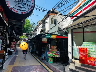 a person walking down a street with a smiley face balloon at White House in Phi Phi Don