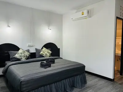 a bedroom with a large bed with a black headboard at White House in Phi Phi Don