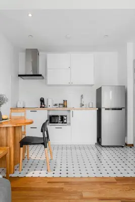 a white kitchen with a table and a refrigerator at Title Halo Andaman Coast Pool View Gym in Nai Yang Beach